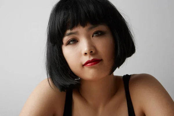 Vista laterale della giovane donna cinese con i capelli corti in posa sullo sfondo bianco. Isolato . — Foto Stock