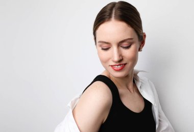 Siyah iç çamaşırı giyen, gülümseyen ve stüdyoda poz veren genç bir kadın. İzole edilmiş.