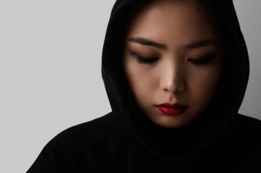Beyaz arka planda poz veren genç Müslüman Asyalı kadının yakın plan portresi. İzole edilmiş.