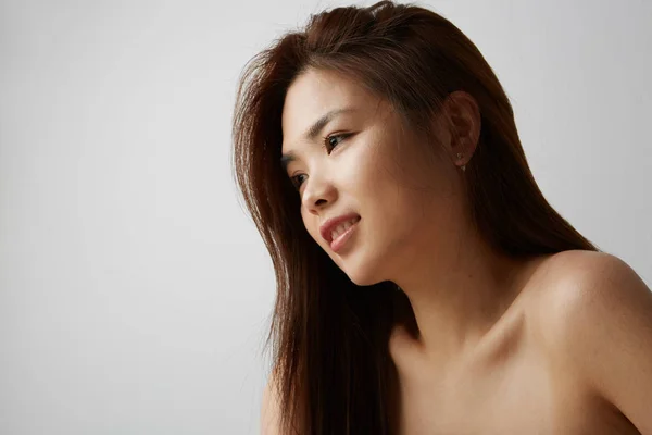Vista laterale della giovane donna cinese in posa sullo sfondo bianco. Isolato . — Foto Stock
