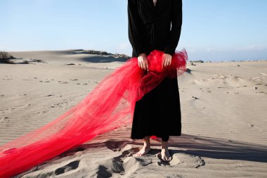 Genç bir kadın kumsalda güneşli havanın tadını çıkarıyor..