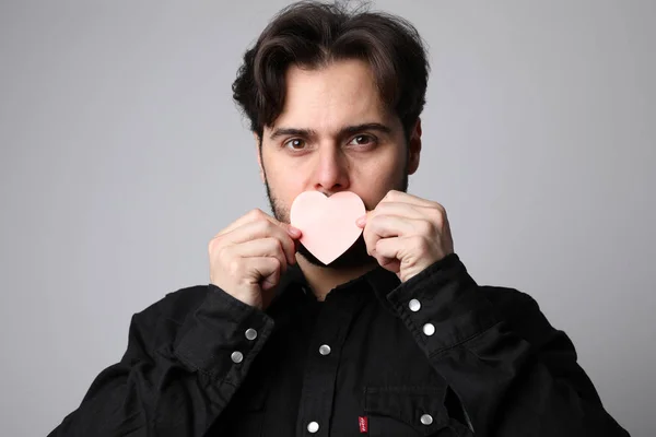 Közelkép egy jóképű férfiról, aki szívjelet tart. San Valentin-nap. — Stock Fotó