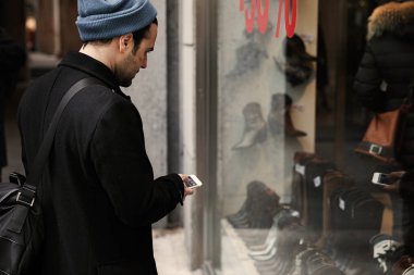 Genç hippi sokakta yürüyor ve vitrinlere bakıyor..