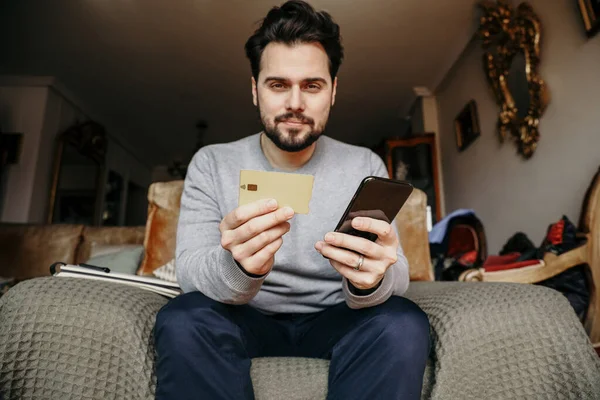 Baard hipster man maakt online bestelling met behulp van credit card. Graantextuur. — Stockfoto