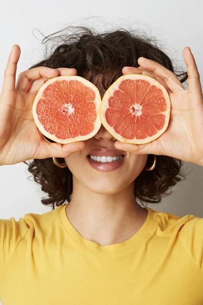 Vitamine C. Close-up portret van een jonge vrouw die op de witte muur poseert. Met positieve emoties. Verticaal — Stockfoto