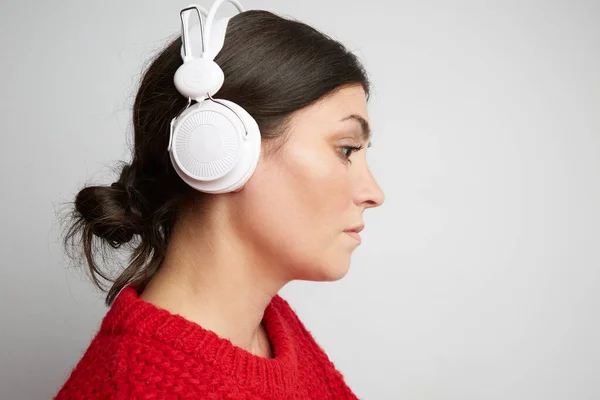 Portret młodej kobiety słuchającej muzyki w białej słuchawce. Poziomy. — Zdjęcie stockowe