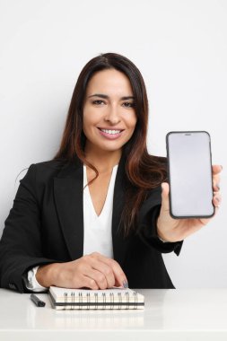 Ofiste akıllı telefonuyla çalışan bir iş kadını. İzole edilmiş.