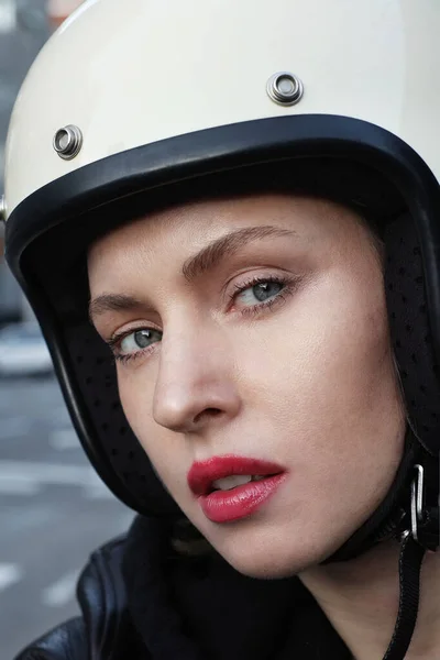 Close-up portrait of biker girl wearing white helmet.