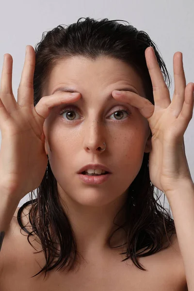 Gros plan portrait d'une jolie fille avec les mains sur le visage faisant un massage. Vertical . — Photo