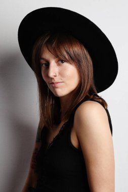 Stüdyoda modaya uygun kıyafetler içinde poz veren genç mutlu hippi kız. Dikey.