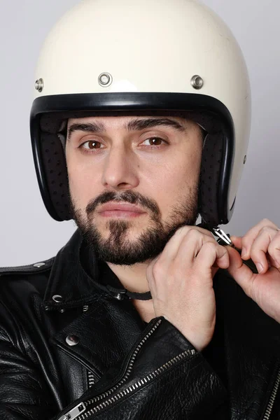 Close-up portrait of young happy biker man with white cafe-racer helmet. White background.
