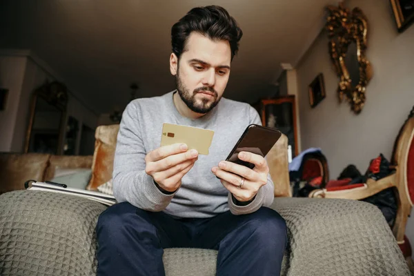 Jonge hipster man doet online boodschappen en gebruikt zijn creditcard. — Stockfoto