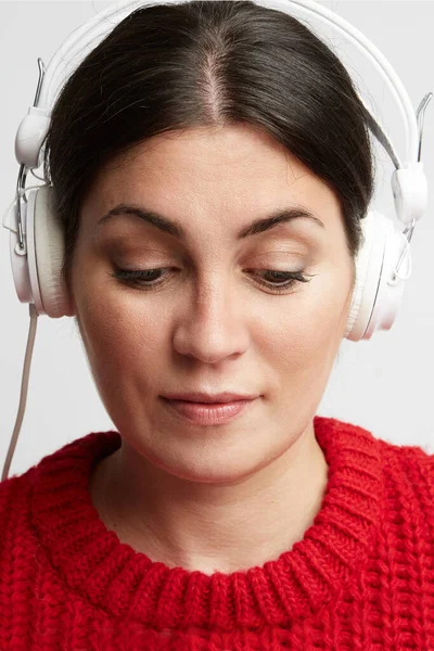 Portret van een jonge vrouw die luistert naar de muziek in haar koptelefoon. Verticaal. — Stockfoto