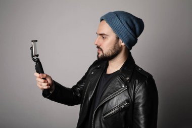 Beyaz arka planda poz veren genç sakallı hippi blogcu. İzole edilmiş