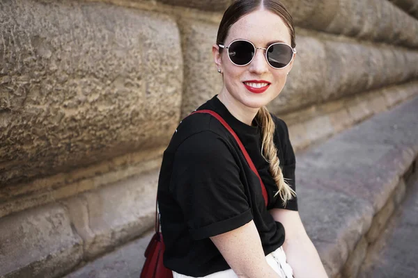 금발 머리의 젊은 여자가 재킷 과 선글라스를 착용하고 웃는 모습. — 스톡 사진