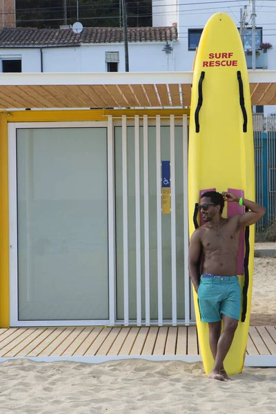 Beau mec noir profitant d'une journée d'été sur la plage dans le camp de surf. Vertical . — Photo