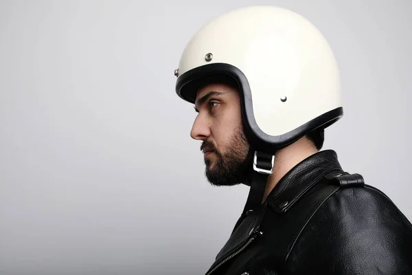 Retrato lateral de cerca del joven motorista barbudo con casco blanco café-corredor. Fondo blanco . — Foto de Stock