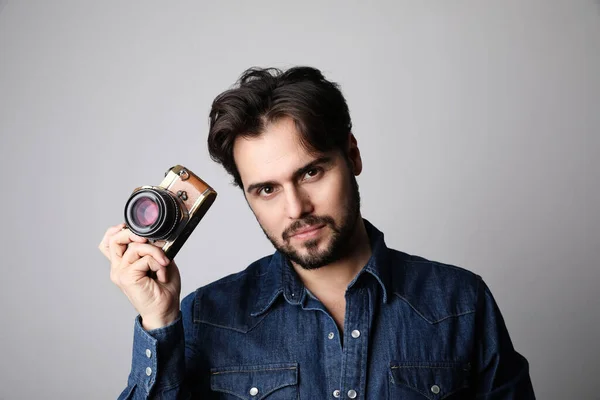 Close up portrait of young bearded man with taking photos using vintage camera, isolated over white background. — Stock Photo, Image