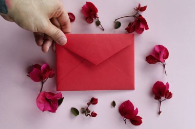 Erkek eli ve bahar çiçeklerinin maketi. Pembe arka planda Fuchsia çiçekleri. Düz yatış, üst görünüm.