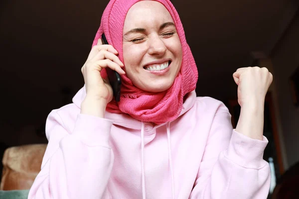 Porträt einer jungen Frau im muslimischen Hijab, die mit emotionalem Gesicht auf dem Smartphone spricht. — Stockfoto