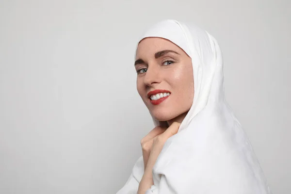 Portrait latéral d'une belle jeune femme musulmane portant un hijab sur la tête regardant la caméra et souriant . — Photo