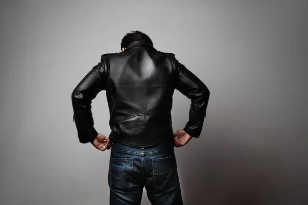 Potret pria mengenakan jaket kulit berdiri kembali di studio. Horisontal. — Stok Foto