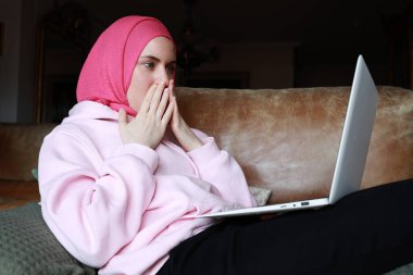 Bilgisayarla çalışan ve yüzüne başörtüsü takan Müslüman bir kadının portresi. İzole edilmiş.