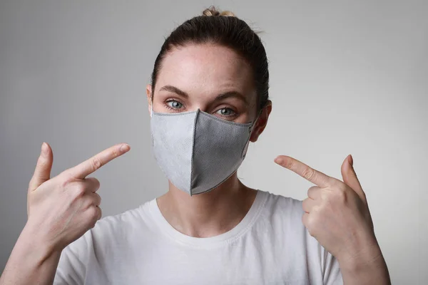 Retrato de mujer joven con máscara de protección facial médica en el interior sobre fondo blanco. Protección del virus . —  Fotos de Stock