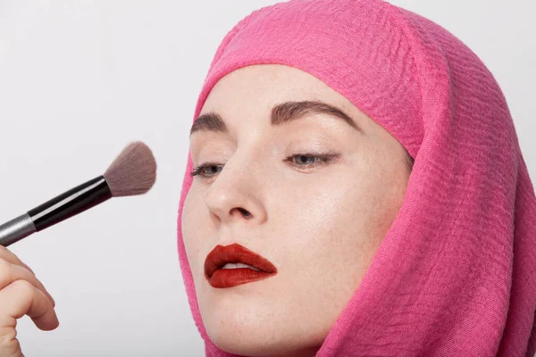 Retrato de close-up de uma mulher muçulmana usando um lenço na cabeça e fazendo maquiagem. Isolados . — Fotografia de Stock