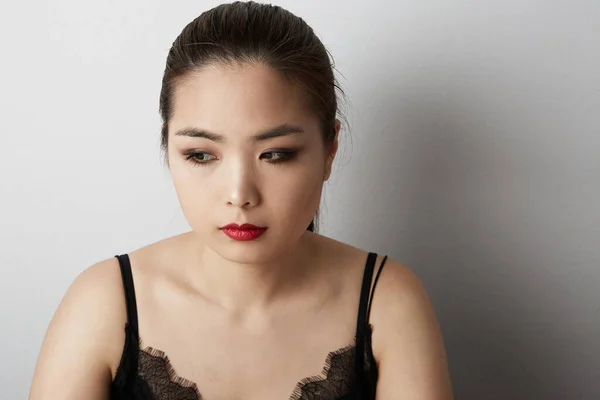 Vonzó ázsiai nő gondolkodik és félrenéz. Fehér alapon elszigetelve. — Stock Fotó