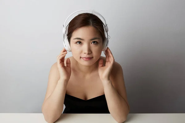 Piękna Atrakcyjna Azjatka słucha muzyki i pozuje na białym tle. Miejsce na tekst. — Zdjęcie stockowe
