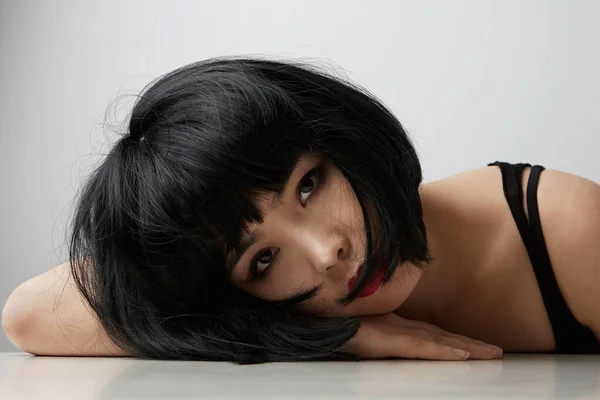 Fénykép komoly ázsiai nő sötét hajú, néz egyenesen a kamerába, pózol fehér háttér. Szépségkoncepció — Stock Fotó