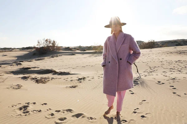 ピンクのコートとフェドーラの帽子を身に着けている自然を身に着けている良い外観の女性モデルの肖像。屋外. — ストック写真