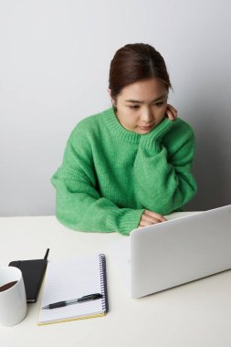 Dizüstü bilgisayar kullanan genç bir kadın. KOBİ girişimcisi veya serbest yaşam tarzı konsepti. Dikey.