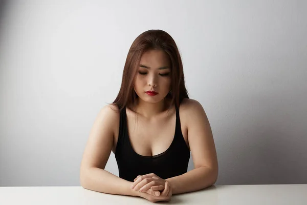 Bella donna asiatica con i capelli lunghi guardando da parte in posa in studio su sfondo nero. Isolato . — Foto Stock