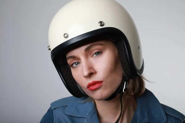 하얀 헬멧을 쓰고 빨간 입술을 가진 자전거를 타는 젊은 여성의 근접 사진. 스튜디오 배경. — 스톡 사진