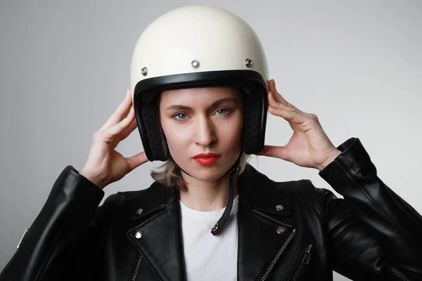 흰색 헬멧을 쓰고 머리를 들고 빨간 입술을 하고 있는 자전거를 타는 젊은 여성의 근접 사진입니다. 스튜디오 배경. — 스톡 사진