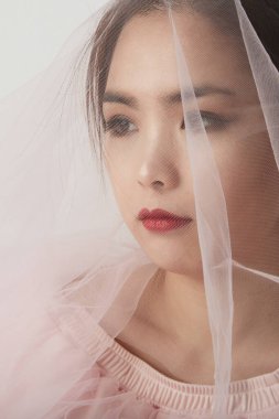 Gelinlik makyajı ve saç stilinde Asyalı bir kadının dikey yakın plan portresi. Pembe stüdyo geçmişi. Metnin için boşluk.