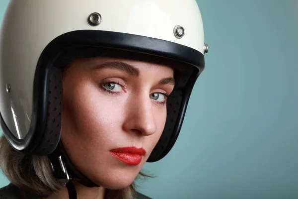 Close-up retrato de motociclista jovem, vestindo capacete branco, com lábios vermelhos. Estúdio fundo azul. Espaço para o seu texto . — Fotografia de Stock