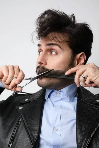 Retrato de homem sênior bonito recebendo styling e aparar de sua barba. Tiro vertical . — Fotografia de Stock