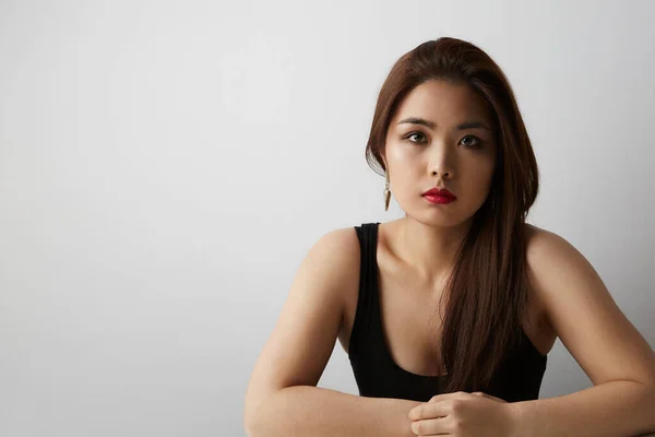 Portret van een prachtige Aziatische vrouw met lang donker haar op zoek naar camera, geïsoleerd over witte achtergrond in de studio — Stockfoto