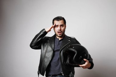 Siyah deri ceket giymiş, kasklı, vahşi sakallı bir motorcuyu vurdu. Metin için boş alan.