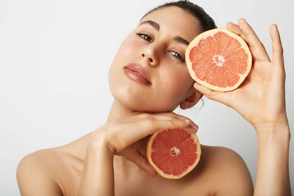 Close-up portret van jonge mooie vrouw met twee sinaasappels poserend over witte achtergrond. Gezond en schoon eten. — Stockfoto