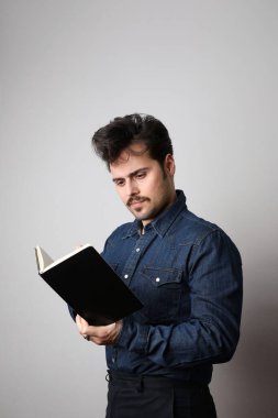 Yapılacaklar listesi yazılıyor. Gömlekli yakışıklı, beyaz arka planda not defterine bir şeyler yazan. Metin için boşluk.