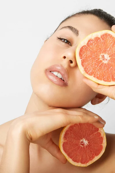 Close-up portret van jonge mooie vrouw met twee sinaasappels poserend over witte achtergrond. Gezond en schoon eten. — Stockfoto