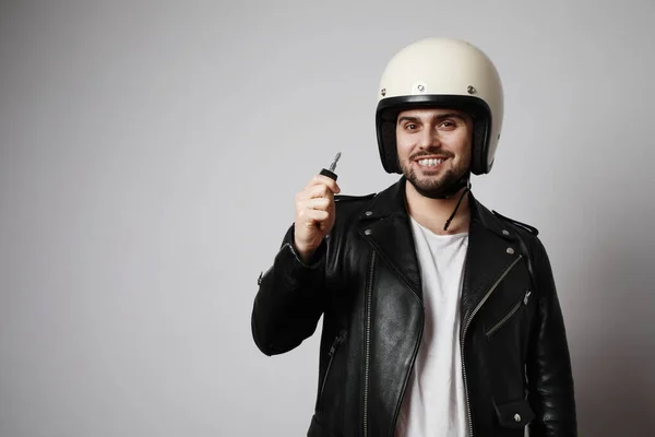 Disparó brutal barbudo motorista con llaves de motocicleta y vestido con una chaqueta de cuero negro. Espacio libre para texto . — Foto de Stock