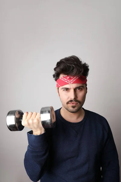 Hombre hipster barbudo tiro vertical haciendo ejercicios de fitness con mancuerna sobre fondo gris en estilo cómico de aspecto retro . —  Fotos de Stock