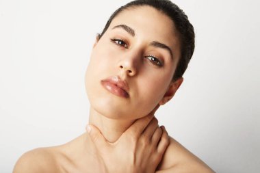 Çıplak omuzlu, çıplak bir kadın kameranın önünde pembe duvarın üzerinde çıplak poz veriyor. Metin için boşluk.