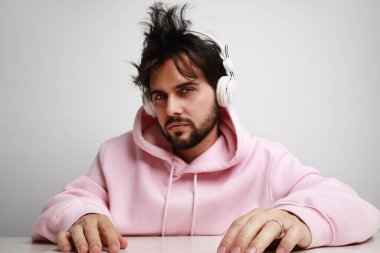 Beyaz arka planda kulaklık takan genç DJ 'in çılgın ve mutlu görüntüsü. Yatay.