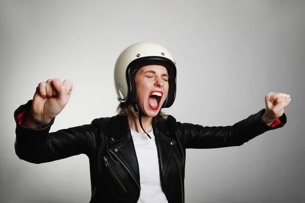 Potret emosional biker wanita muda mengenakan helm sepeda motor, berpura-pura mengendarai sepeda. Terisolasi. — Stok Foto